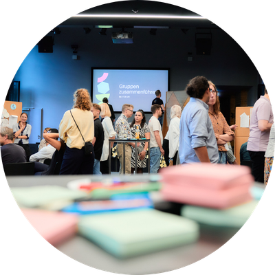 Event Guter Move mit Postits und Präsentation im Hintergrund viele Menschen