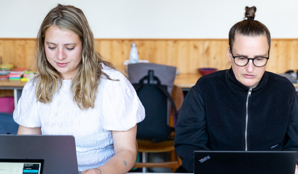 ki-schnupperkurs-einsteiger-wohlfahrt-guter-move KI Schnupperkurs, Ki Einführung: Almut und Aurelija Trainerinnen bei Guter Move sitzen am Tisch und schauen auf Laptops